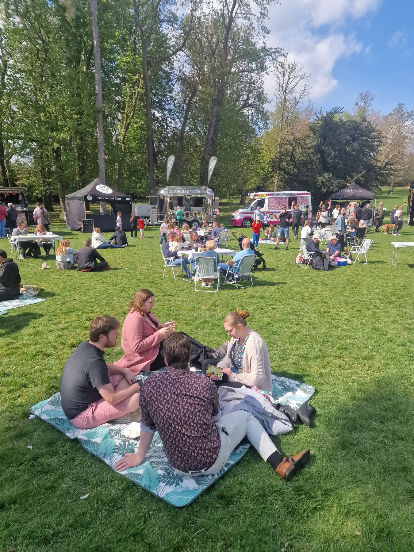 Visitors relaxing on a borrowed picnic blanket at Christchurch Park Market