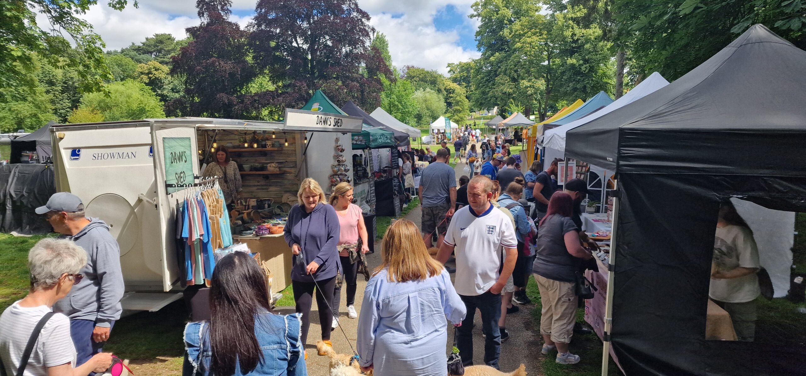 Visitors shopping at independent stalls along the Christchurch Park Market pathway