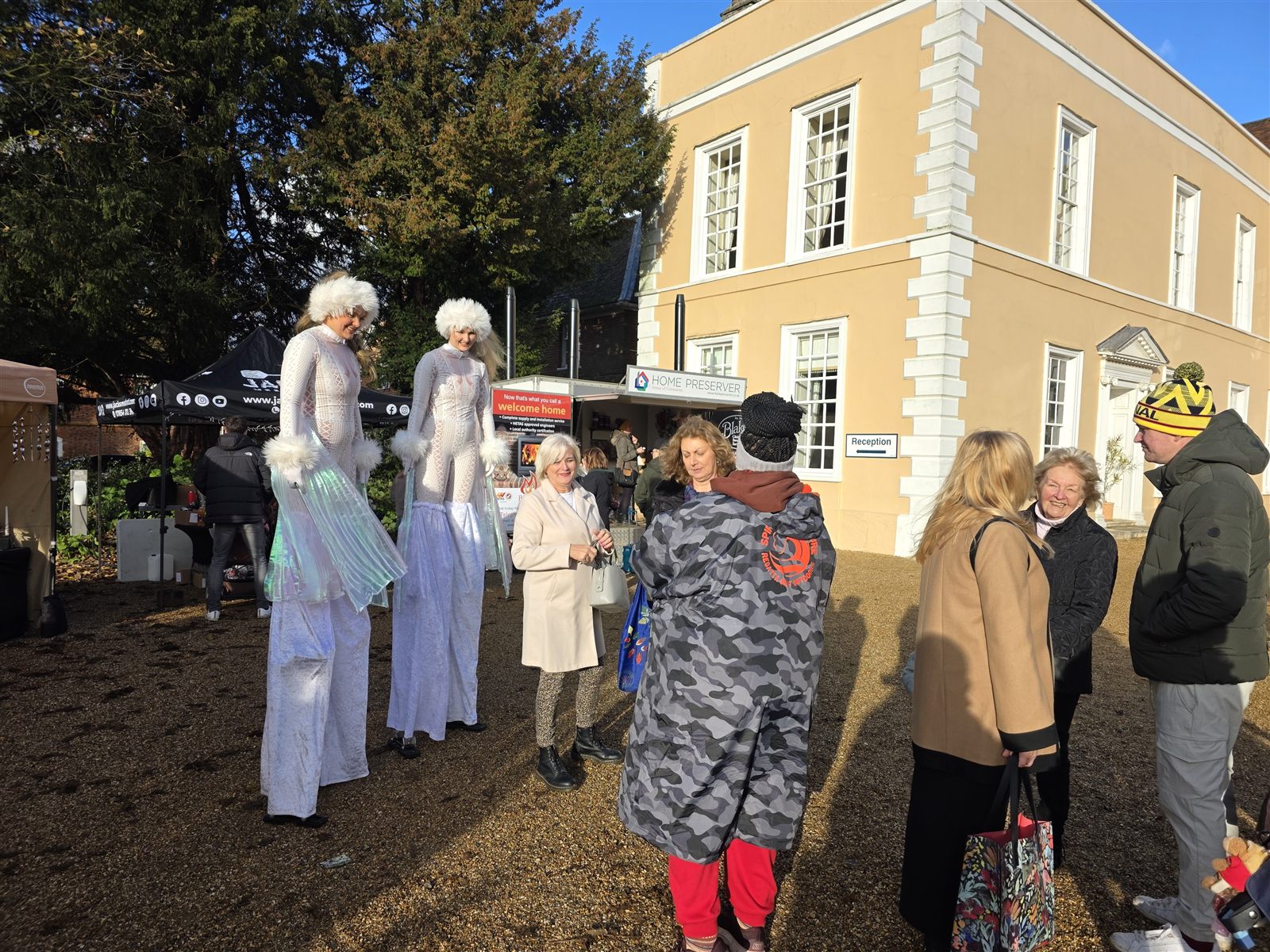 Festive stilt walkers meeting visitors outside Hintlesham Hall