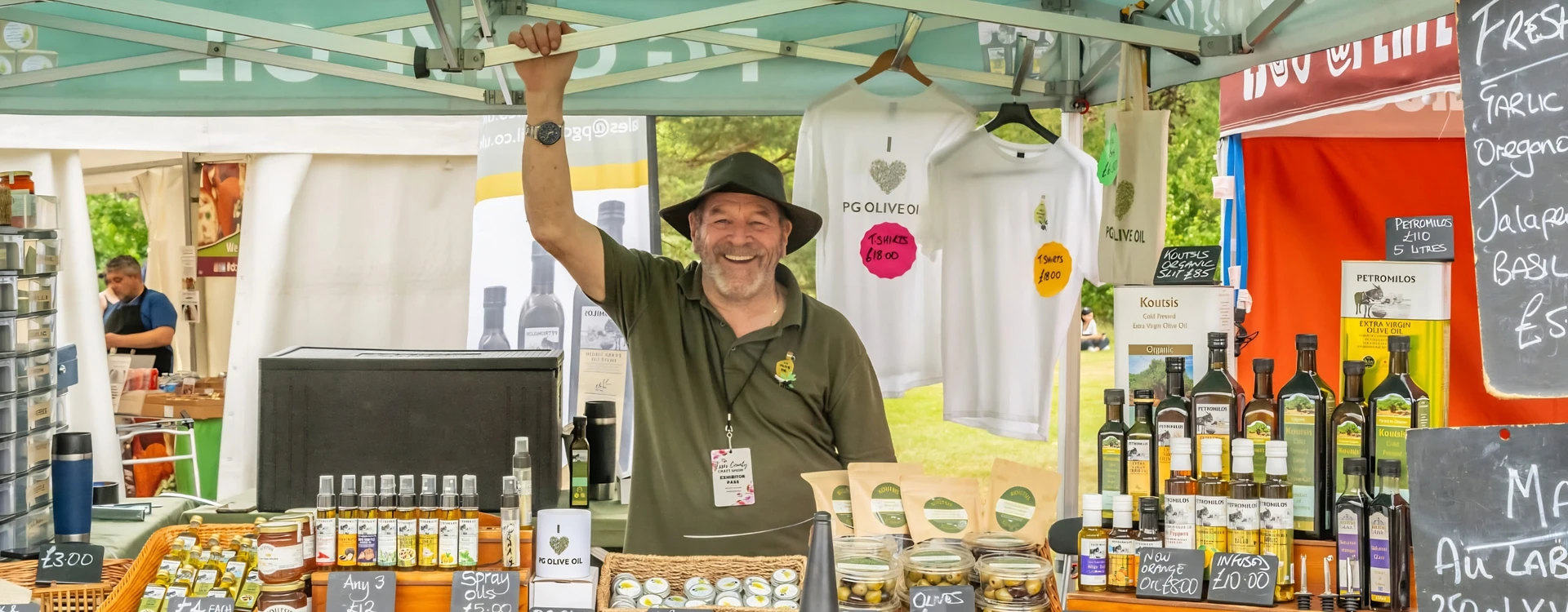 Phil from PG Olives smiling behind his market stall