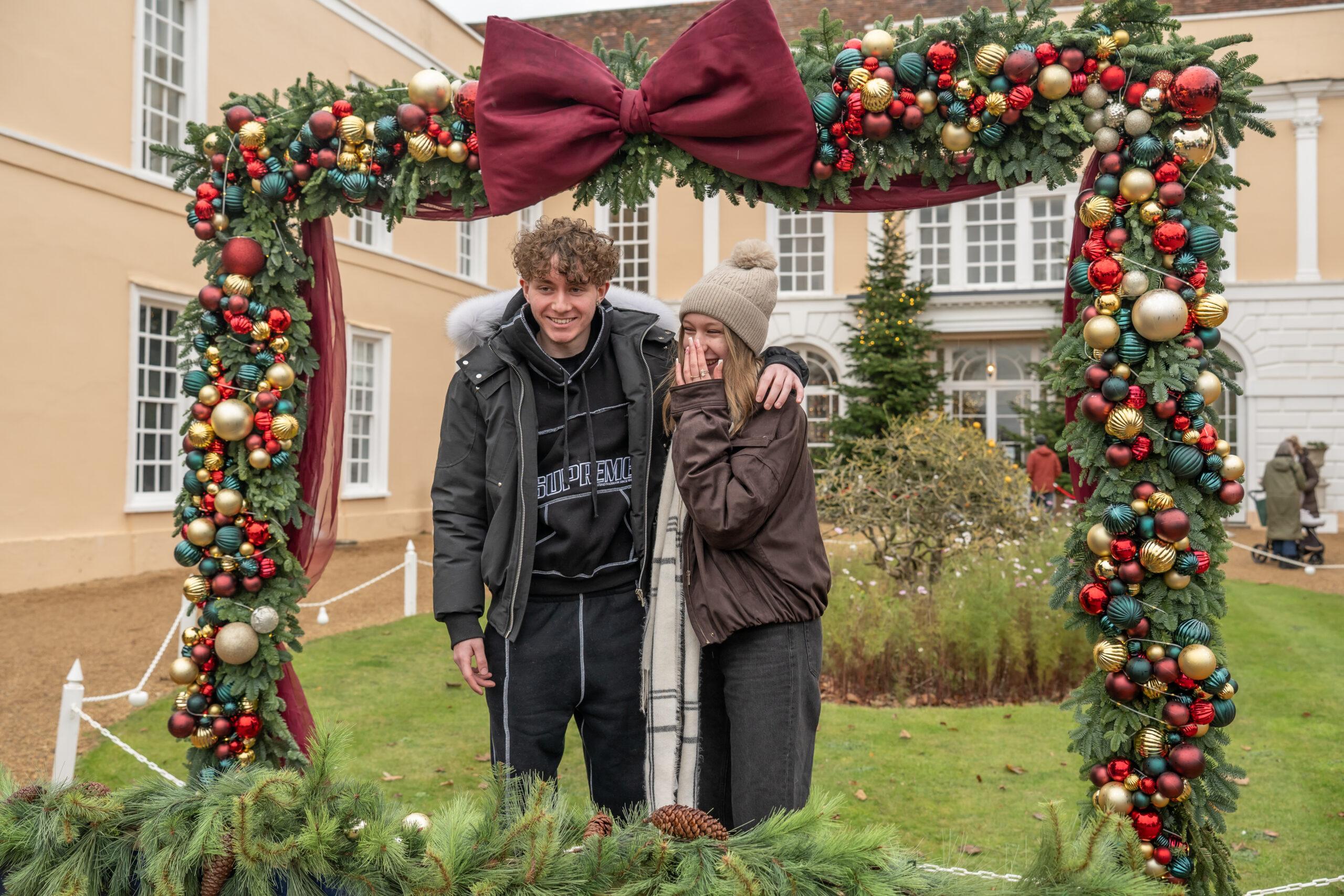 Two visitors posing in the festive photo frame at Hintlesham Hall