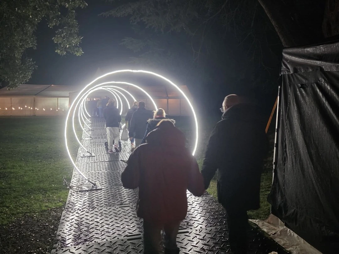 Visitors walking through glowing light hoops at the fair